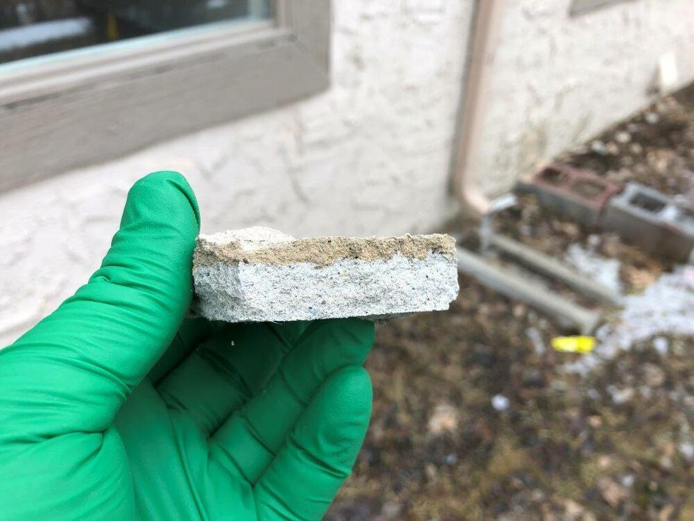 Gloved surveyor collecting an asbestos wall sample